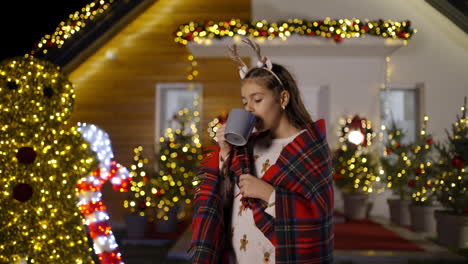 girl drinking a warm drink at christmas