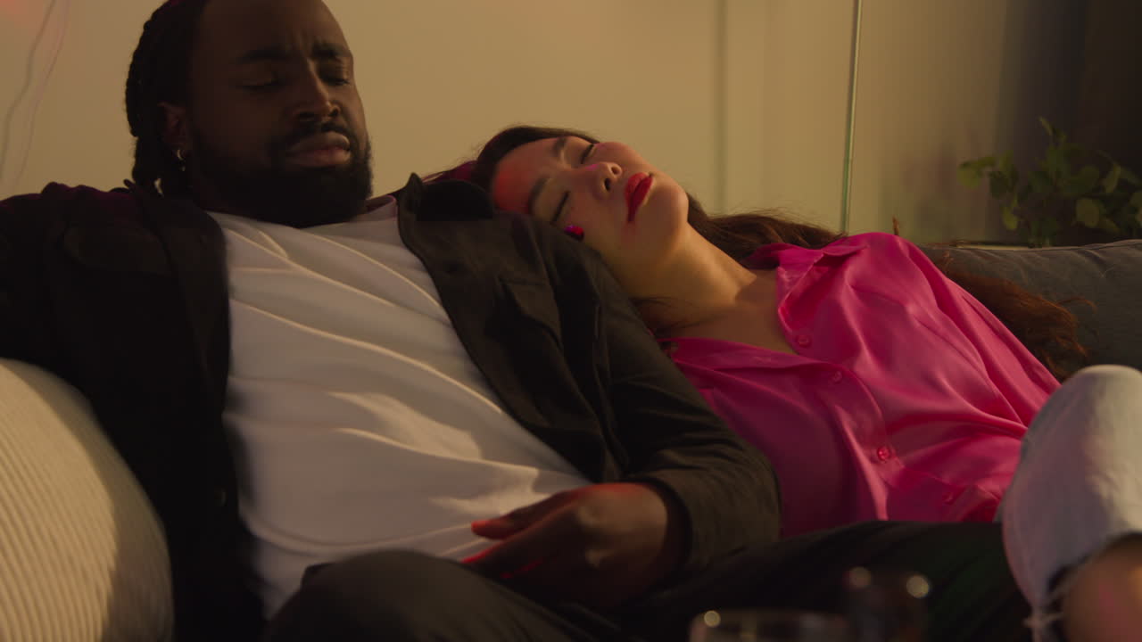 primer plano de una pareja despertando en el sofá después de beber alcohol en una fiesta de casa sufriendo de resaca 1