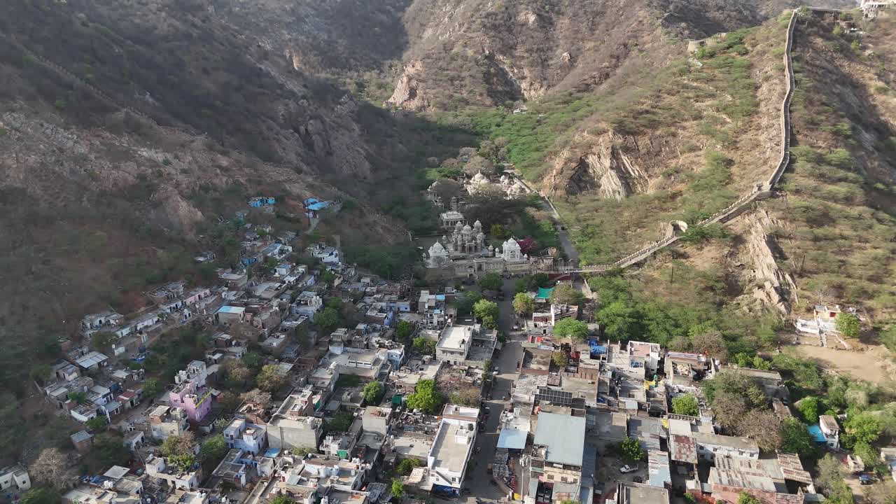 High-angle view of a majestic hilltop fort overlooking the dense city below with temples