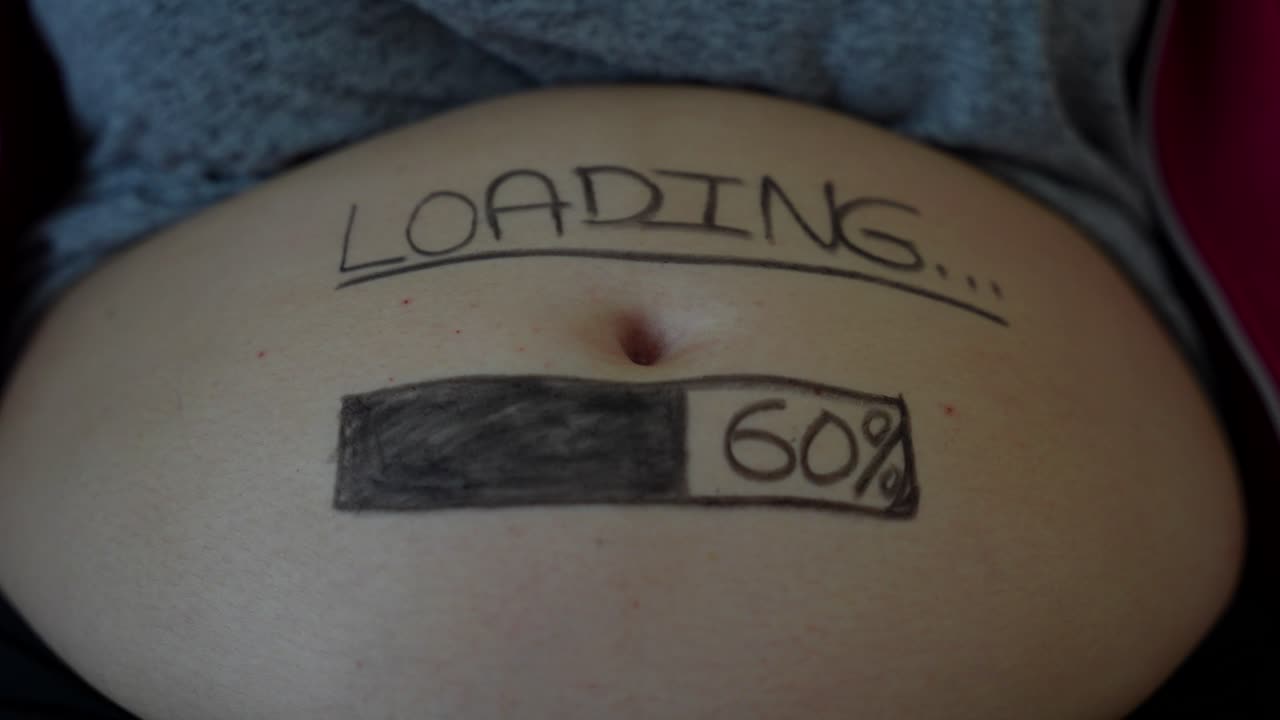 24 weeks pregnant belly with a loading bar painted on it. Close up