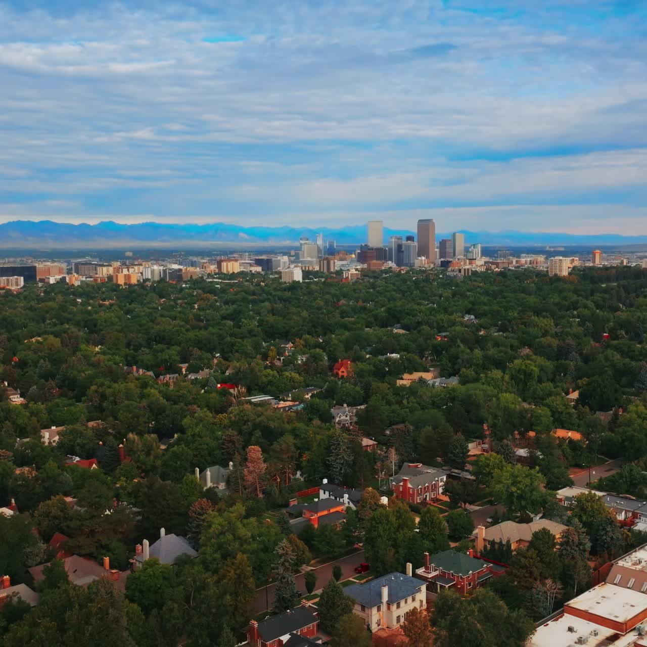 Descending over the green scenery of amazing Denver, Colorado, USA at daytime. Blue cloudy sky at backdrop