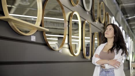 woman browsing modern mirror displays in a home decor store