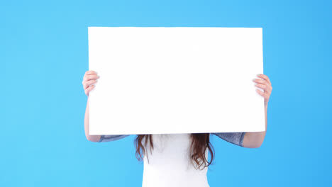 beautiful woman holding blank placard on blue background