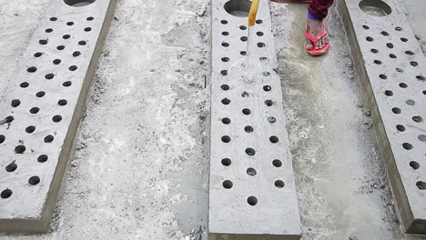 indian mason worker pouring water over concrete to accelerate the hardening process, industrial construction scene