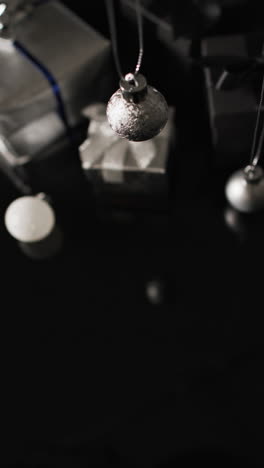 vertical video of silver baubles christmas decorations and copy space on black background