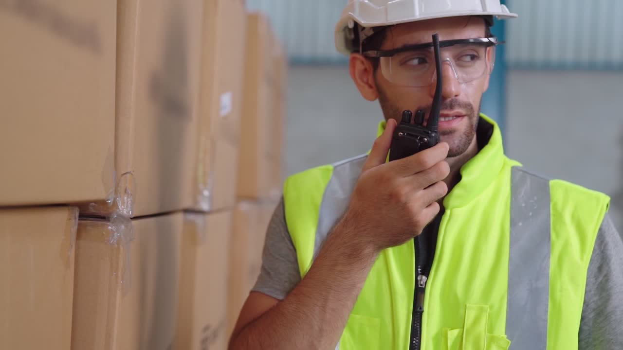 trabajador de carga profesional habla por radio portátil para comunicarse con otro trabajador