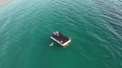 slow motion shot of peoplejumping from floating platform in coogee beach