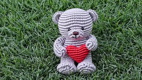 crochet teddy bear with heart on grass