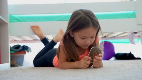chica usando un teléfono móvil de vidrio en el piso 4k