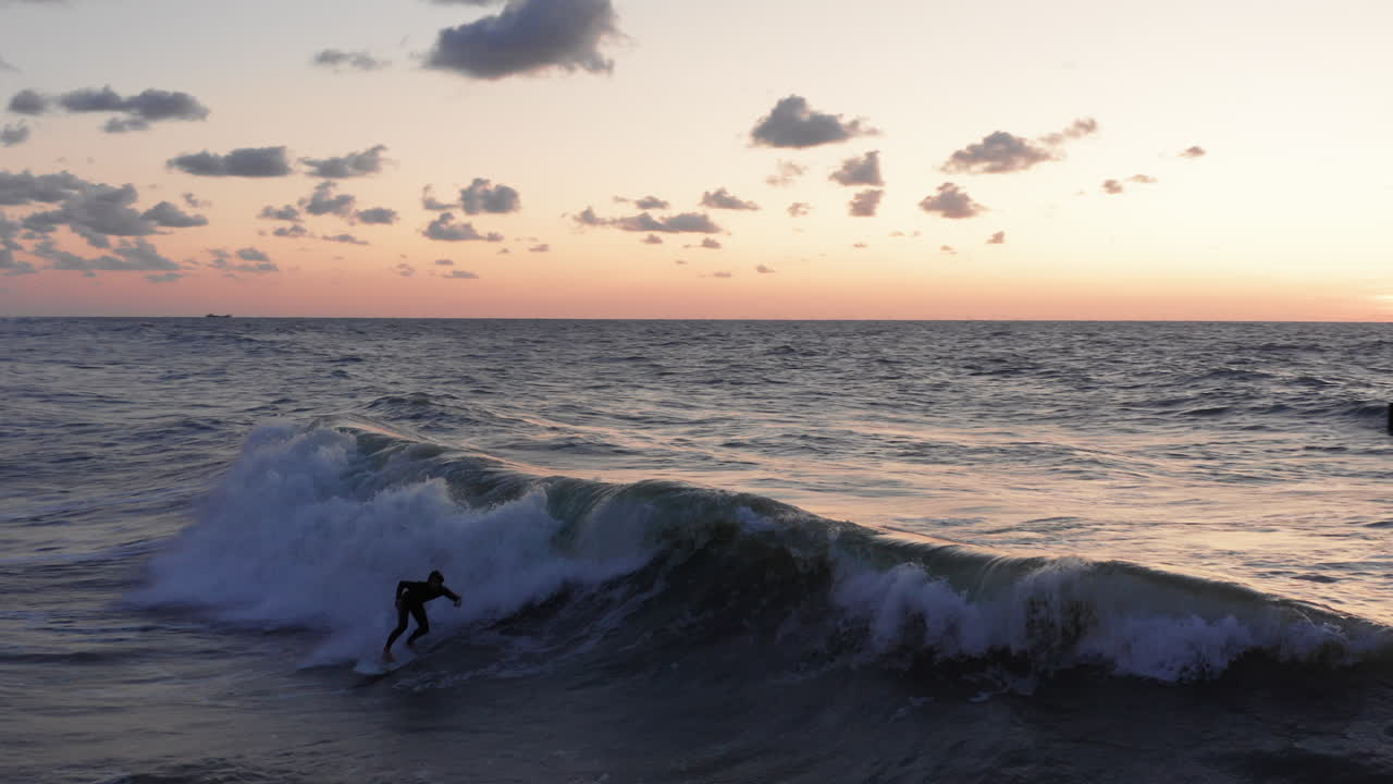 surfistas frente a la ciudad turística domburg en los países bajos durante la puesta de sol