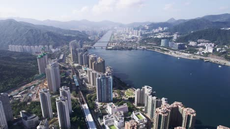 high skyscrapers between the mountains of lion rock country park and shing mun river on a cloudy sunny day