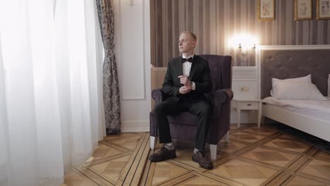 man on chair put on wrist watch, groom dresses male businessman waiting for meeting, hand with clock