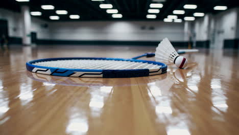 badminton racket and shuttlecock on court floor