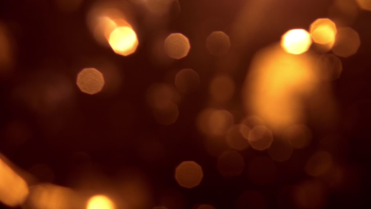 Luci bokeh dorate astratte scintillanti su sfondo scuro