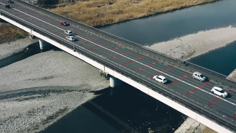 vehicles and pedestrian crossing mutsumi bridge over tama river at daytime in tokyo, japan