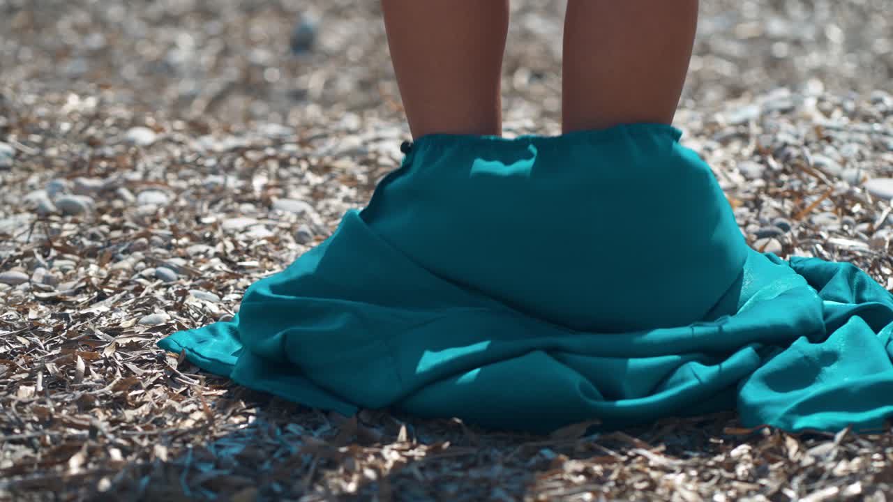 mujer se desnuda para bañarse en la playa de guijarros del mediterráneo