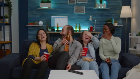 multiethnic friends laughing while watching comedy movie enjoying time spend together