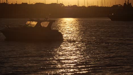 sunset on newcastle harbour with silhouette boat passing, beautiful sun reflection