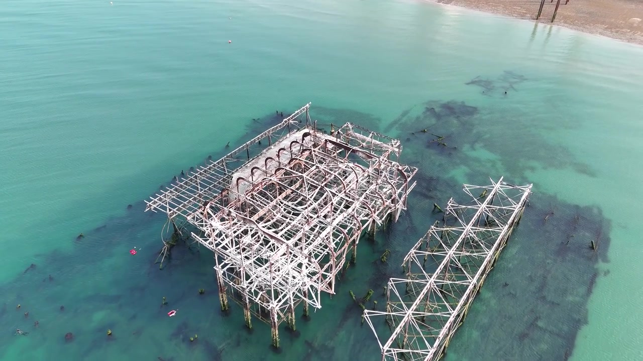 Rare aerial view of Brighton West Pier ruins during exceptionally low tide, exposing forgotten Victorian engineering usually hidden below the English Channel.
