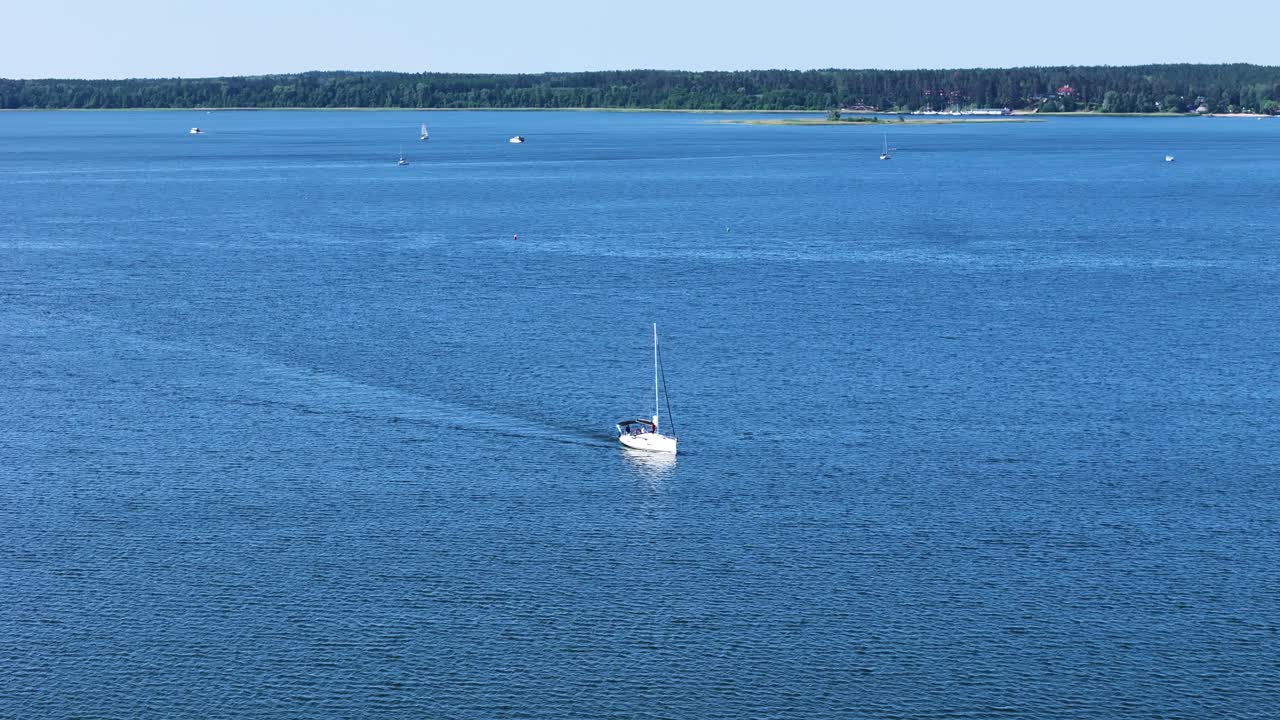 Private yacht with sail in massive lake, aerial view