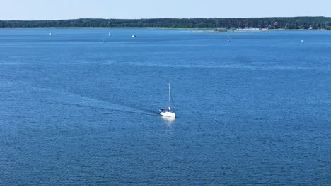 private yacht with sail in massive lake, aerial view