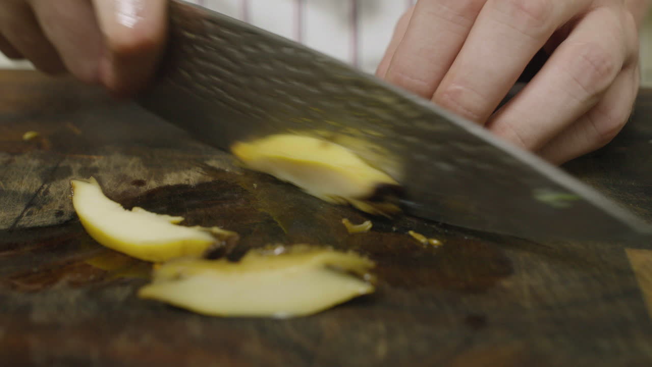 Slicing abalone seafood mollusk on cut board with kitchen knife