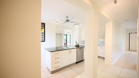 luxurious modern home staged design kitchen with angled wall and small homewarming gifts on black countertop