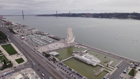 Kreisende-Luftaufnahme-Der-Lissabonner-Uferpromenade-Mit-Dem-Padrao-Dos-Descobrimentos-Denkmal