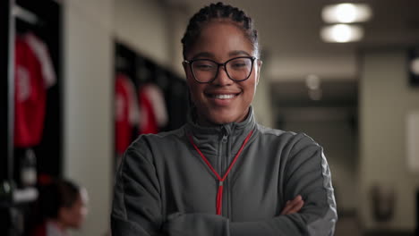 portrait of a smiling female coach in a locker room