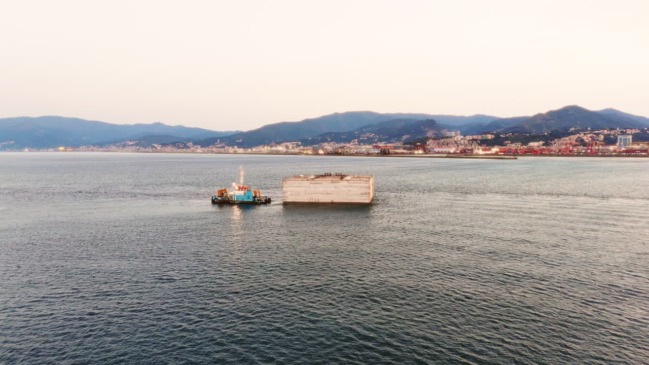 Tugs industrial boat operating in the Mediterranean Sea at sunset