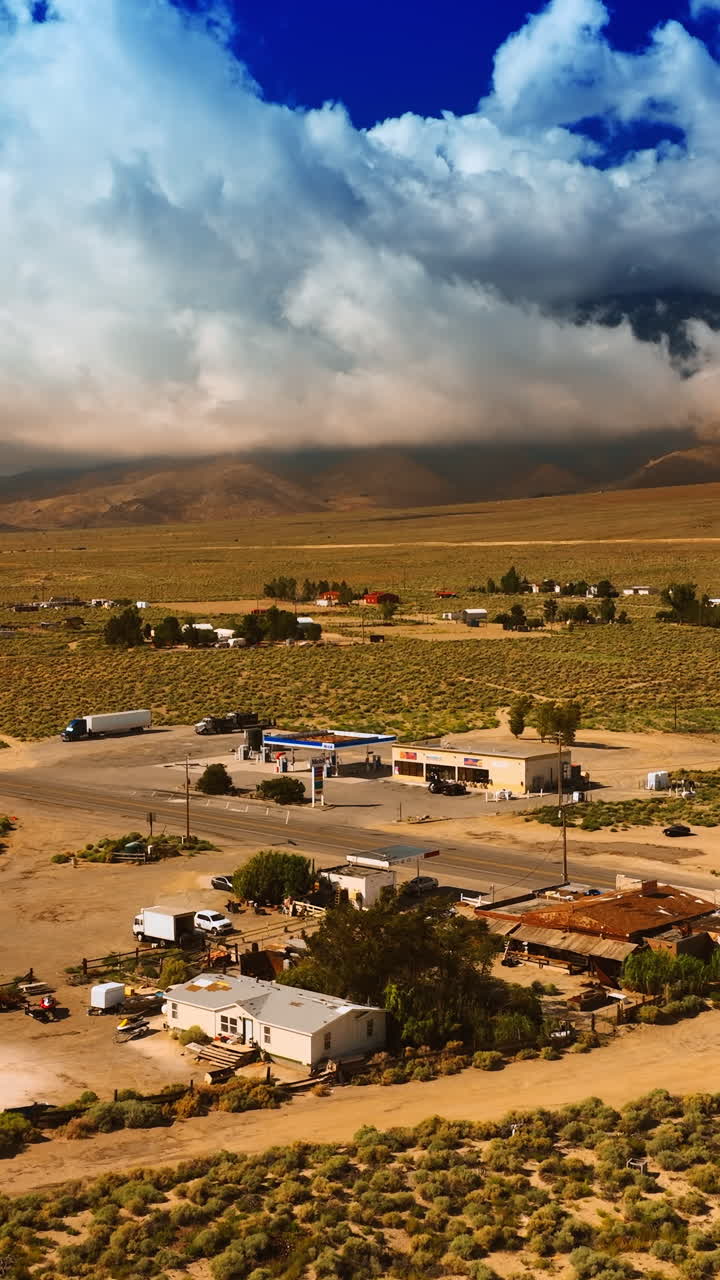Approaching the village in the desert of Death Valley, California. Some households are scattered in the area around the highway. Mountains hidden by clouds at backdrop. Vertical video