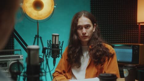 young guy talking in mic during interview in podcast recording studio