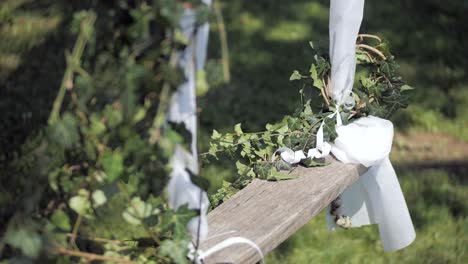 romantic wedding decor swing decorated with ivy and white cloth, closeup