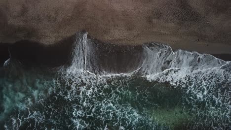 Aerial-view-wave-crashing-sandy-beach,-top-angle