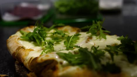 preparing a pizza with arugula