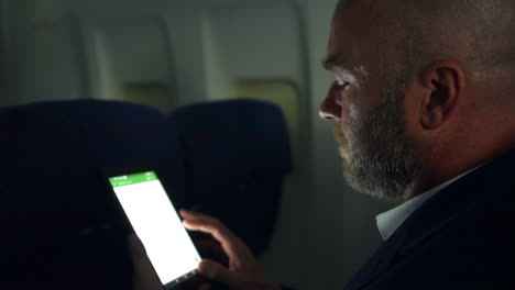 Primer-Plano-De-Un-Hombre-Trabajando-En-Una-Tableta-En-Un-Vuelo-Nocturno-En-Un-Avión-De-Línea