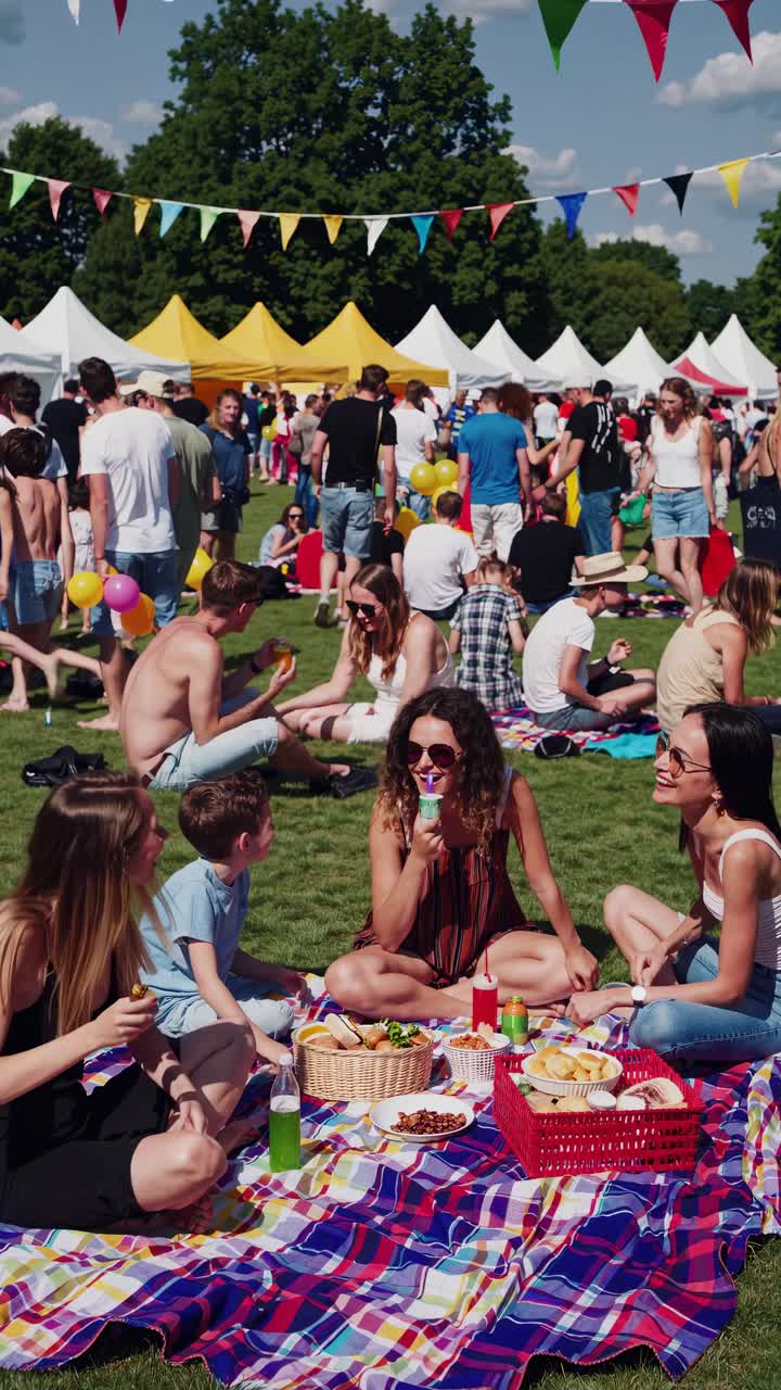 Aerial video captures a vibrant outdoor festival with colorful tents and relaxed attendees