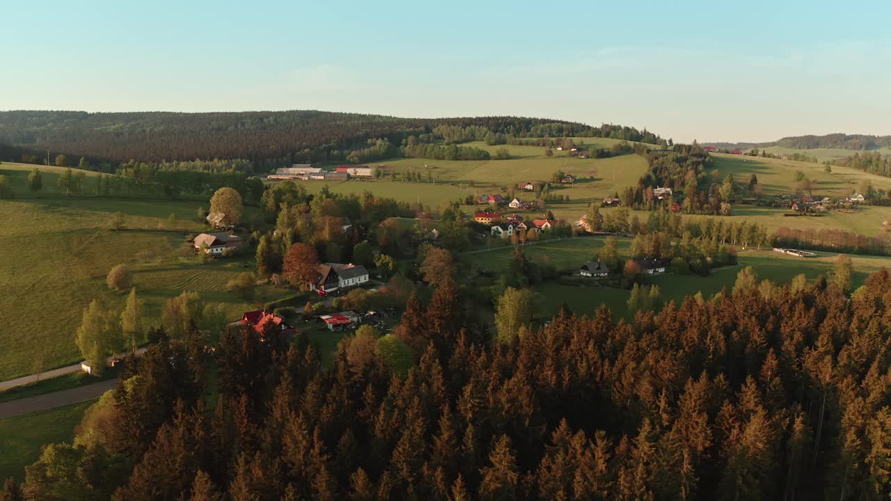 해가 지는 동안 숲으로 둘러싸인 체코 고원 마을의 드론  ⁇