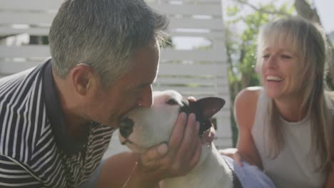 Couple-washing-dog-in-their-garden-