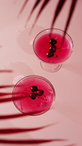 vertical video of close up of drinks with cherries on white background, with copy space