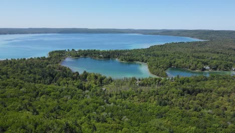 Great-lakes-of-Michigan-surrounded-by-forest-landscape,-aerial-view