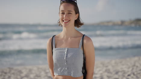 portrait of attractive young woman smiling on beach looking cheerful enjoying warm summer vacation day at seaside ocean excited caucasian female tourist