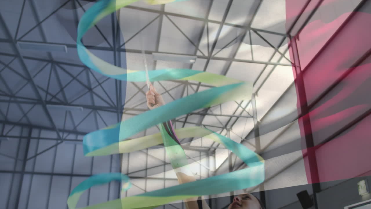 Gymnast performing with ribbon, colorful swirling animation over indoor sports arena