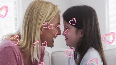 animation of hearts over happy caucasian woman and her daughter sitting on sofa, embracing