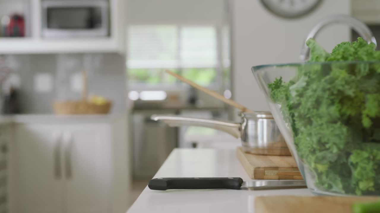 キッチンでサラダが入ったボウルと調理器具がカウンタートップに置かれているビデオ