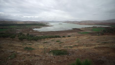 Schöne-Landschaft-Des-Ruhigen-Sees,-Umgeben-Von-Kämmen-Unter-Bewölktem-Himmel-In-Marokko