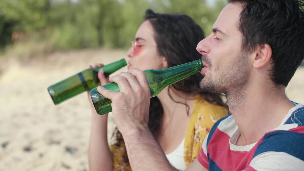 pareja joven bebiendo cerveza fría en la playa/dabrowa gornicza/polonia