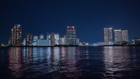 Night-light-Tokyo,-Tsukuda,-Toyosu-skyscrapers-and-bridge-the-Sumida-River-Yakatabune,-pleasure-boat