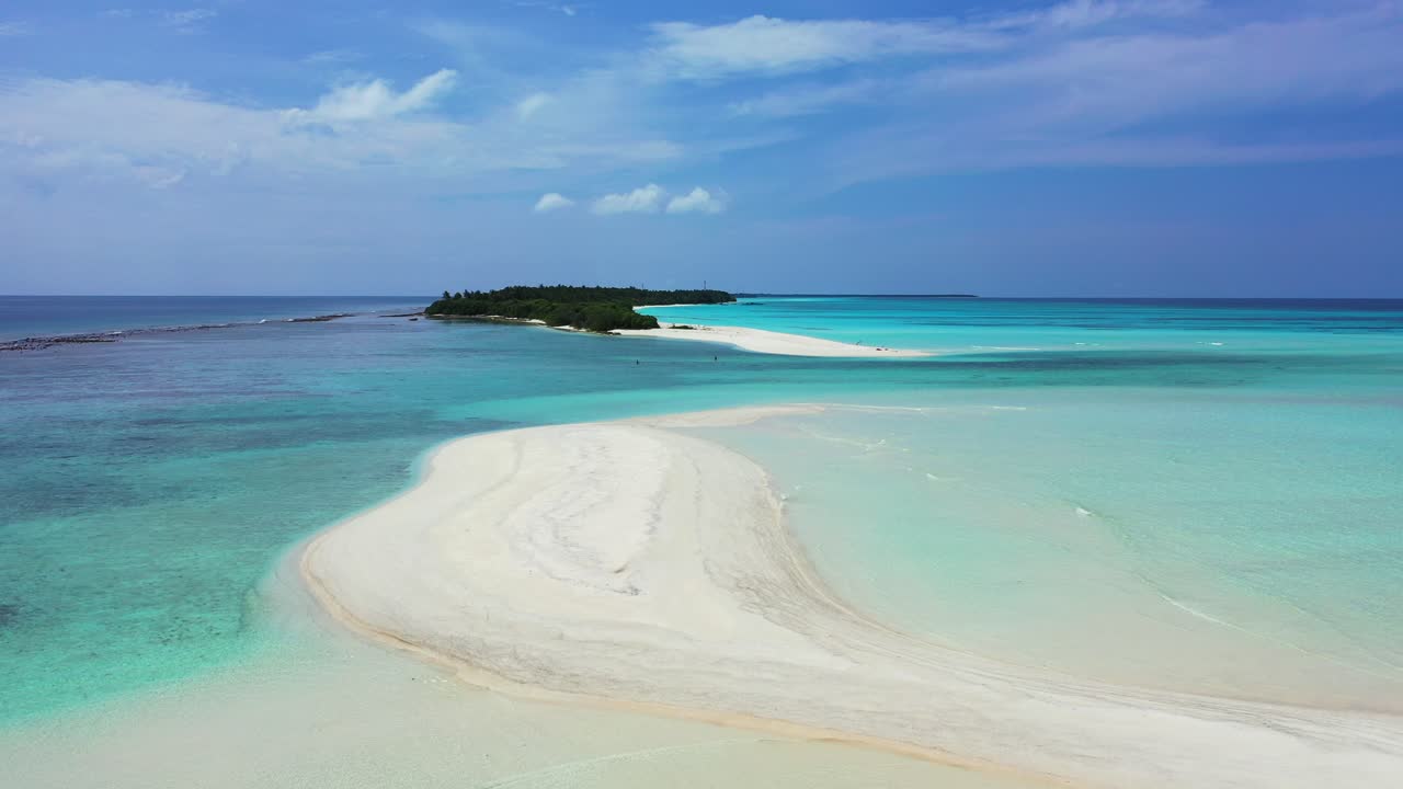 Spiaggia incontaminata di sabbia bianca bagnata da acqua calma e limpida di una laguna turchese vicino a una piccola e splendida isola tropicale nelle Maldive.