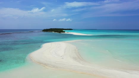 unspoiled white sandy stripe beach washed by calm clear water of turquoise lagoon near beautiful tiny tropical island in maldives